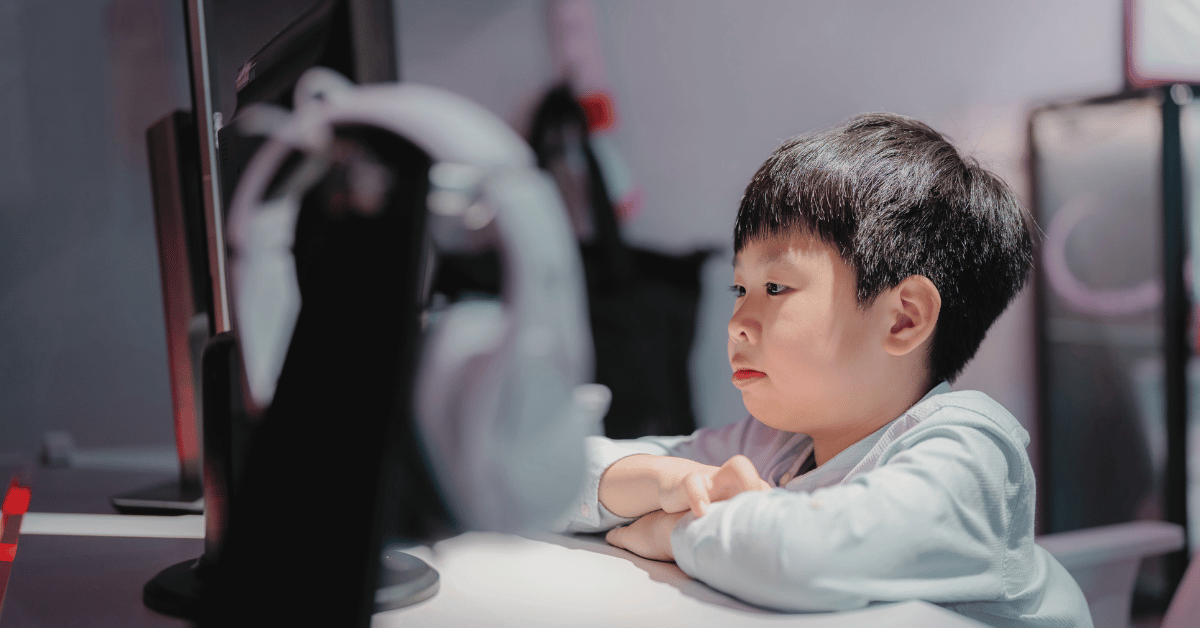 young boy stares at computer screen